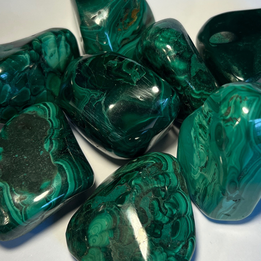 Tumbled malachite stone with striking green bulls-eye patterns, known for emotional healing, creativity, and protection.