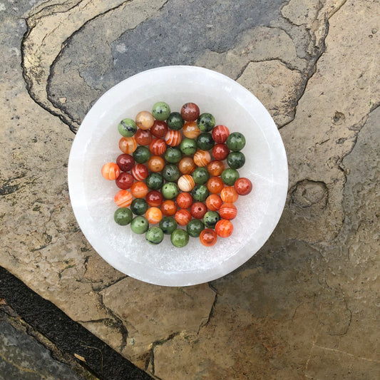Dark green jade and vibrant orange carnelian beaded bracelet symbolizing creativity, balance, and motivation.